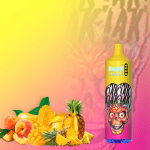 RandM Tornado 9000 vape with vibrant alien skull artwork, surrounded by tropical fruits including mango, peach, and pineapple on a yellow-pink gradient background.
