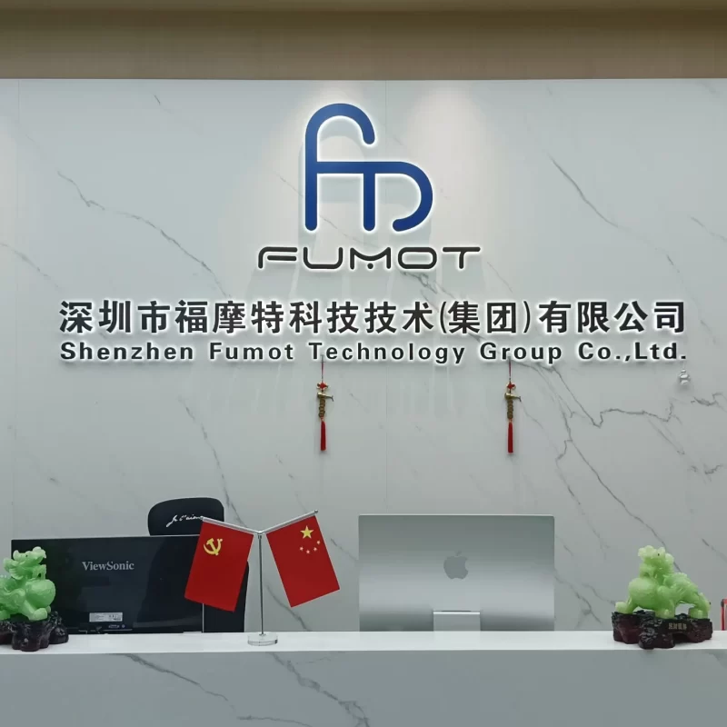 Reception desk of Shenzhen Fumot Technology Group Co., Ltd. with company logo, Chinese flags, and minimalist marble decor